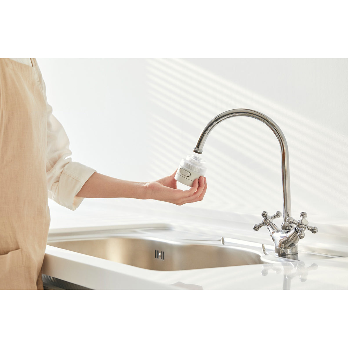 Kitchen shower head filter cap near chrome sink faucet over white basin