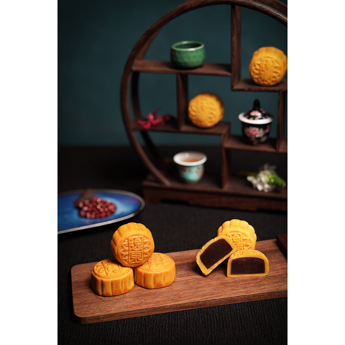 Mini mooncakes arranged on a wooden board with a round display shelf
