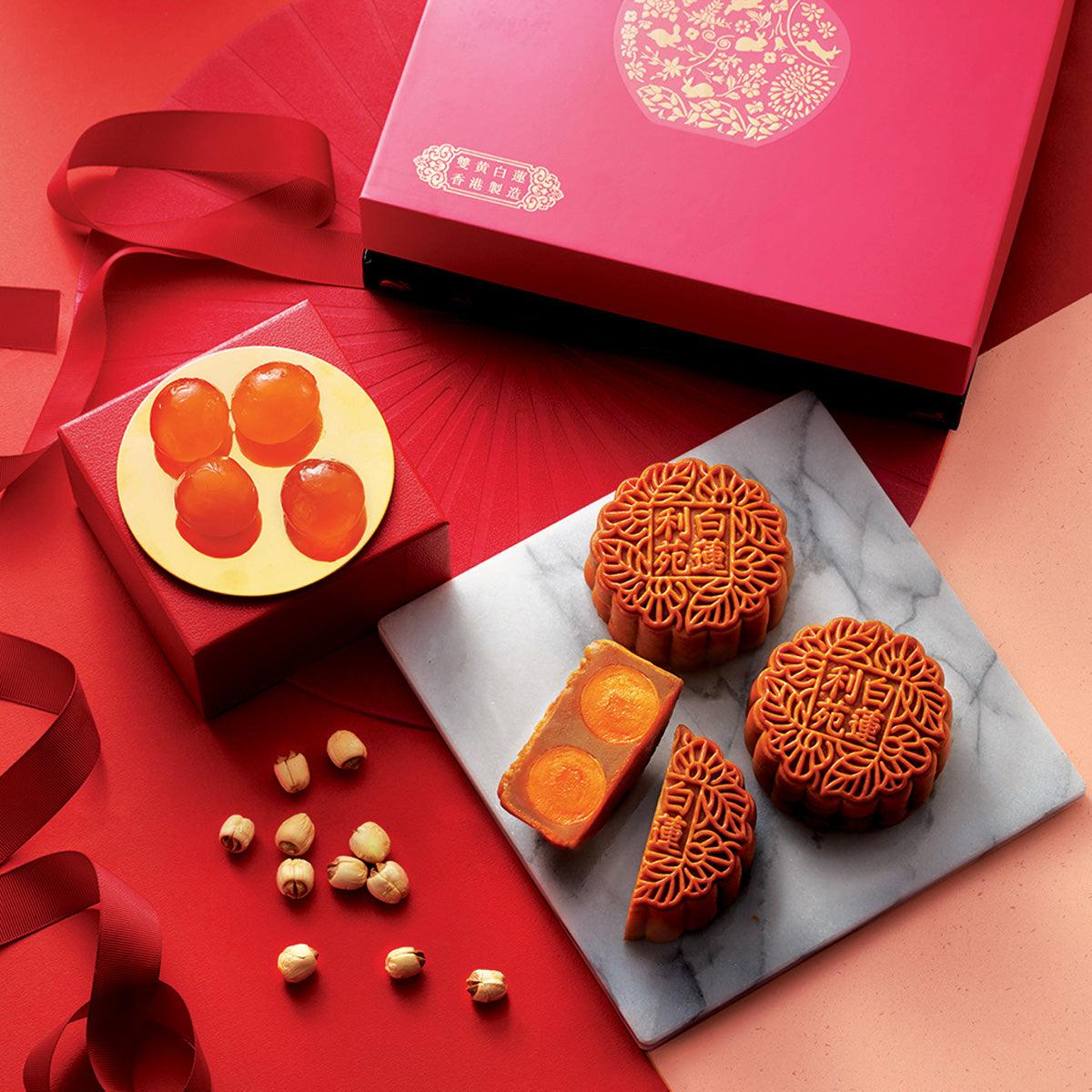 Lotus seed paste mooncake with visible double yolk halves, in wrapper.