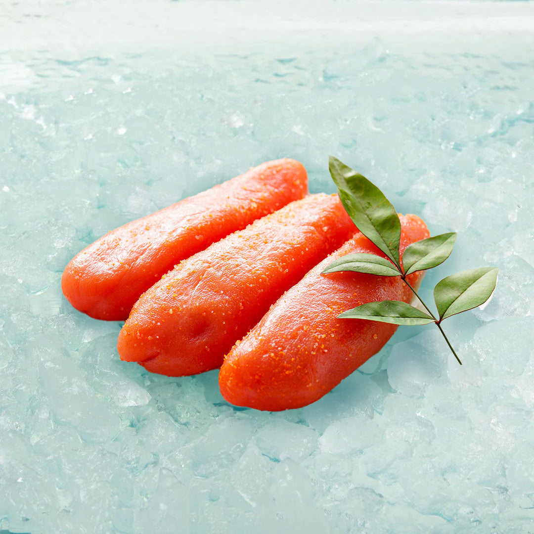 Seasoned cod roe pieces, orange-red with chili flakes and green leaf garnish