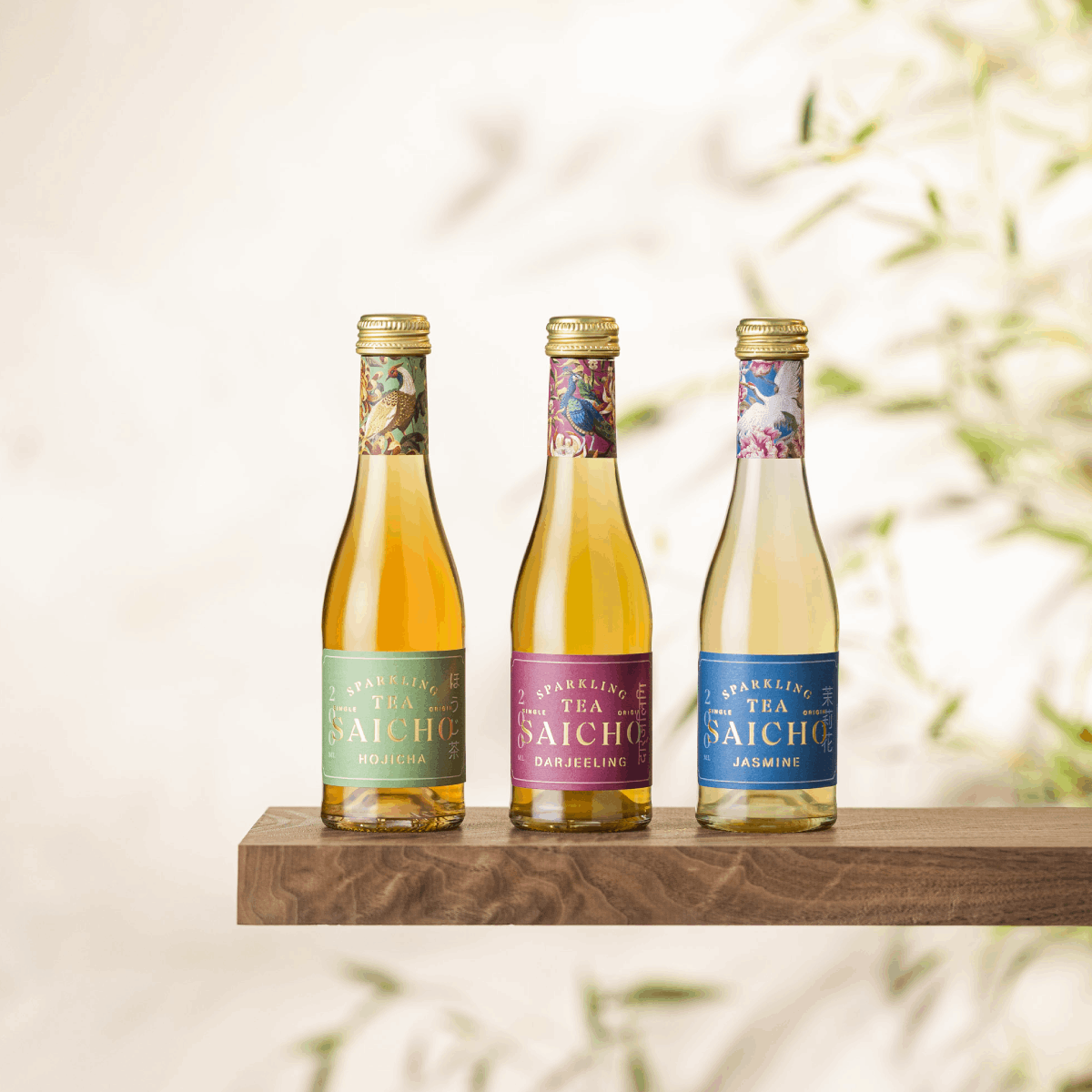 Set of three sparkling tea bottles on a wooden display shelf